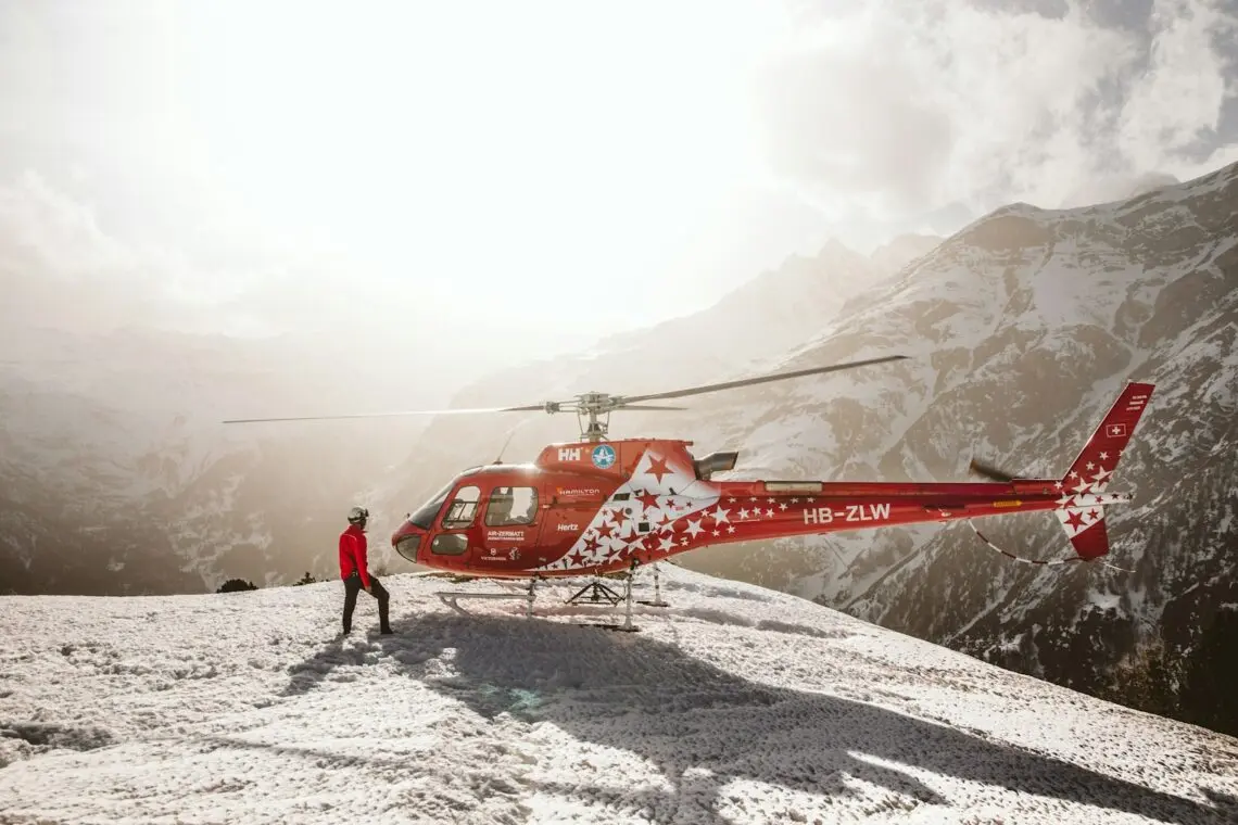 Sauveteur près d un hélicoptère de secours posé sur la neige