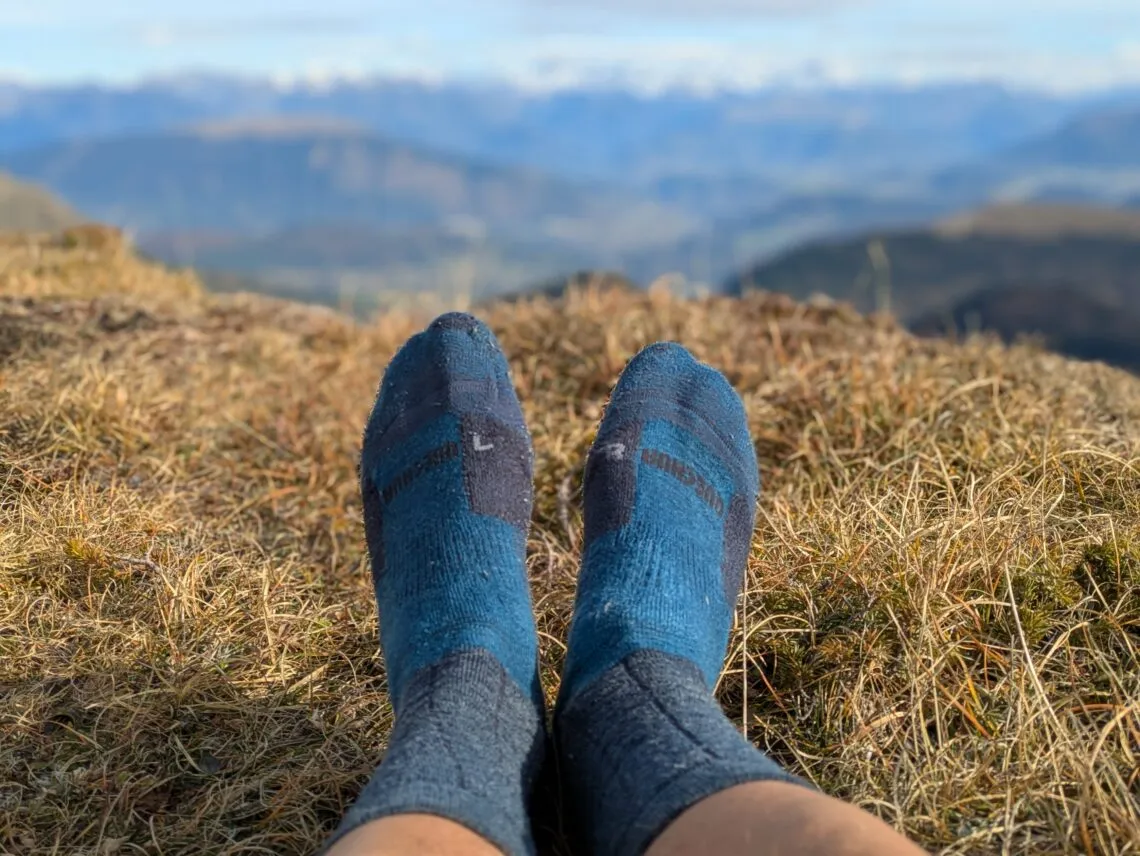 Pieds en chaussettes de randonnée face au panorama de montagne