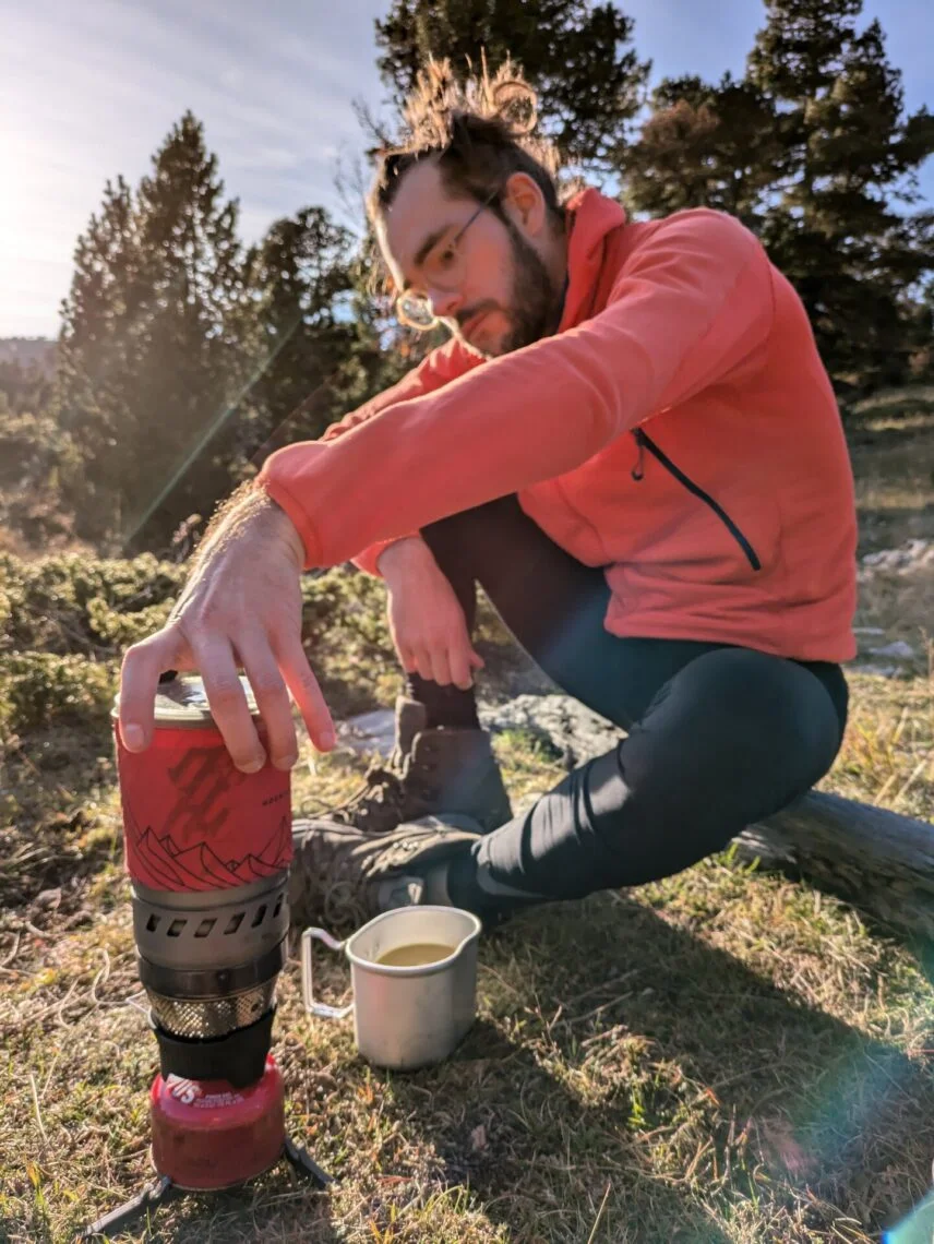 Randonneur saisissant à pleine main le pot du réchaud MSR WindBurner